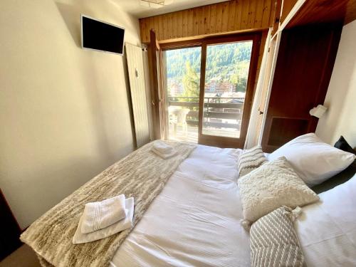 南达Sunny mountain view apartment in town by Jolidi的一张大床,位于带大窗户的房间里