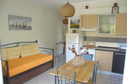 雷夫卡达镇Maria Apartments的客厅配有沙发和餐桌,厨房配有桌子