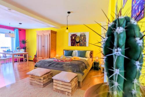 于尔岑Casa de Pancho - Lateinamerika direkt in der City von Uelzen的一间卧室配有一张黄色墙壁和仙人掌床