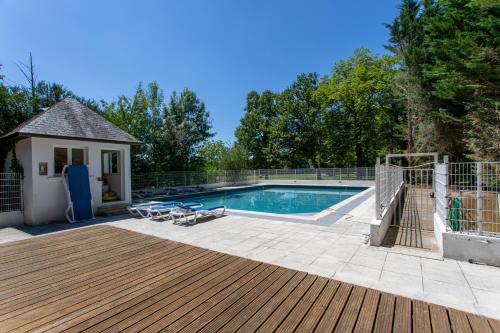 塞雷拉龙德瑞泽城堡酒店的一个带木甲板和房子的游泳池