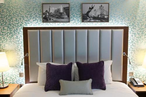 伦敦贝尔格拉维酒店的卧室配有一张墙上有两张照片的床。