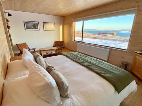 纳塔列斯港Line Hotel Patagonia的一间卧室设有一张大床和大窗户