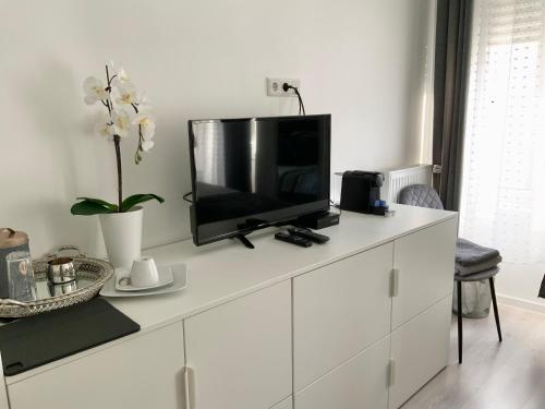 卢森堡EXECUTIVE DOUBLE ROOM WITH EN-SUITE IN GUEST HOUSE CITY CENTRE r4的白色橱柜顶部的电视