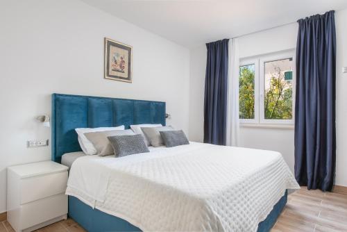 卡斯特尔·斯塔费力克Apartment Kiki的一间卧室配有一张大床和蓝色床头板