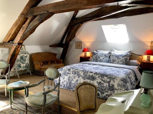 TaingyManoir de La Croix Saint Louis "Luxury Guest House"的阁楼上一间卧室配有床和椅子