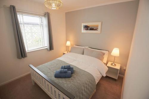 Perranuthnoe3-Bedroom bungalow with parking, Goldsithney, Penzance, Cornwall的一间卧室配有一张蓝色座椅的大床