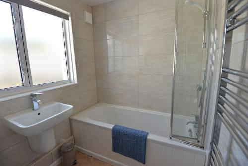 Perranuthnoe3-Bedroom bungalow with parking, Goldsithney, Penzance, Cornwall的带浴缸、水槽和淋浴的浴室
