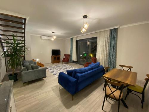 特拉布宗Sky Villa Hisar的客厅配有蓝色的沙发和桌子