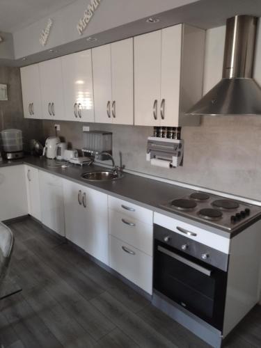 希贝尼克Mare kuća za odmor的厨房配有白色橱柜和炉灶烤箱。