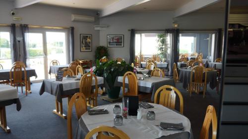 索恩河畔贝尔维尔博若莱的魅力酒店的餐厅用餐室配有桌椅和桌子。