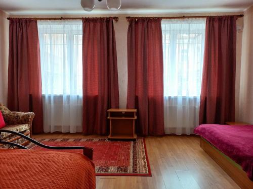 陶格夫匹尔斯Daugavpils City Centеr Apartment的一间卧室设有两张床和红色窗帘