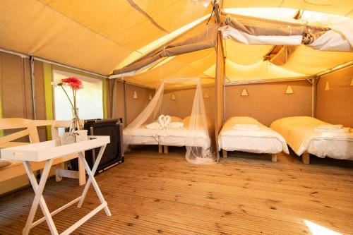 坎丕里亚麦利蒂玛Blucamp的一间帐篷内带两张床和一张书桌的房间