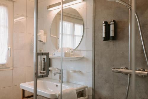 杜尔巴赫林德杜尔巴赫酒店的带淋浴、盥洗盆和镜子的浴室