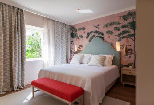 察夫塔特Hotel Supetar的一间卧室配有一张床和一张红色长凳