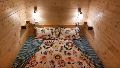 Pîrîu CîrjeiTiny house Casa Axa的木制客房的一张床位,配有两个枕头