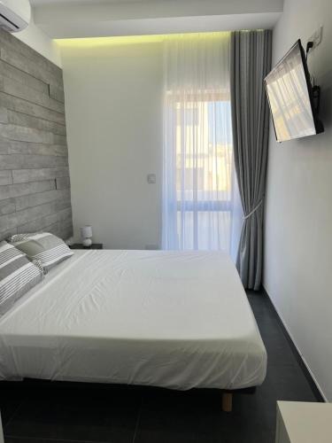 圣保罗湾城Cosy & Modern Top Floor 1-bedroom Apartment的一间卧室设有一张大床和一个窗户。