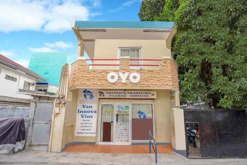 马尼拉OYO 808 Mye Tourist Inn的前面有卵石标志的建筑