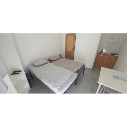 奥西耶克Budget Apartman LeLo Centar 3的小房间设有一张床和一张桌子