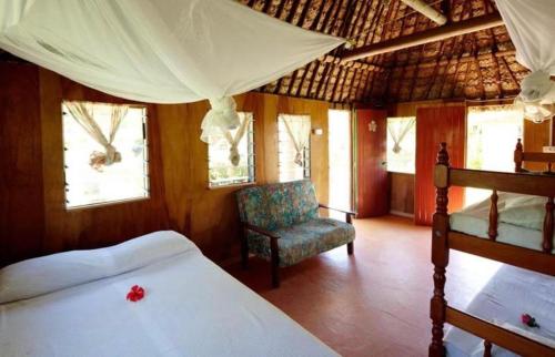 纳库拉岛Nabua Lodge的一间卧室配有一张床和一把椅子
