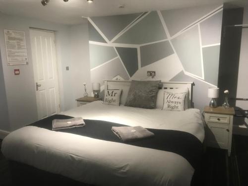 曼彻斯特曼彻斯特皇后旅馆的一间卧室设有一张带几何墙的大床