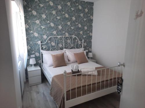 内图诺GUEST HOUSE TRA CIELO E MARE的一间卧室配有一张带花卉壁纸的床