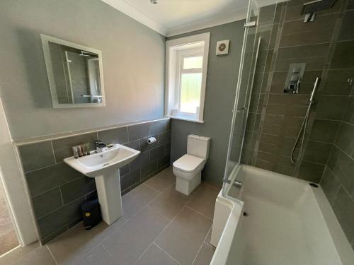 伯恩茅斯Bayside GuestHouse的一间带水槽、卫生间和淋浴的浴室