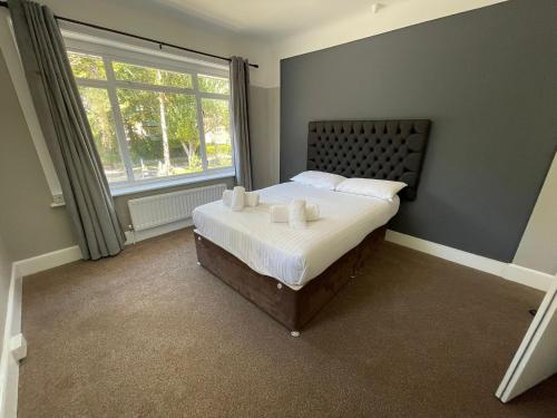 伯恩茅斯Bayside GuestHouse的一间卧室配有一张带白色床单的床和一扇窗户。