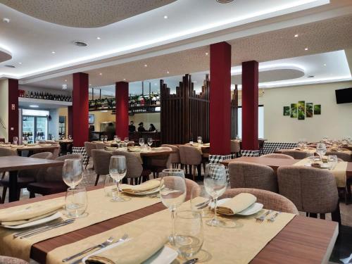 蓬德利马Hotel Império do Norte的配有桌椅和酒杯的餐厅
