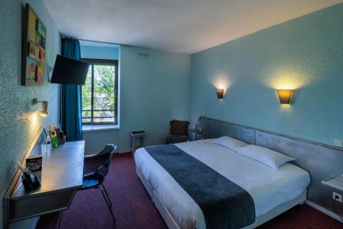 布里夫拉盖亚尔德Noemys Brive - ex Hôtel Restaurant Le Teinchurier的配有一张床、一张书桌和一扇窗户的酒店客房