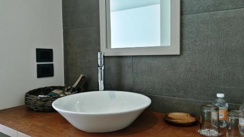 科米坦德多明格斯Hotel Nak'An Secreto Maya的浴室内一个柜台上的白色碗