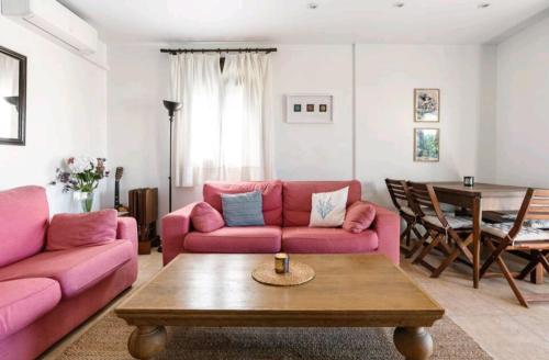 卡拉德米哈斯Beach House的客厅配有粉红色的沙发和桌子