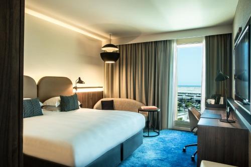 尼斯Crowne Plaza - Nice - Grand Arenas, an IHG Hotel的酒店客房设有一张床和一个大窗户