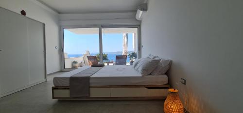 莱切省卡斯特罗Bona Vitae - Attico Vista Mare Castro的一间卧室设有一张床和一个大窗户