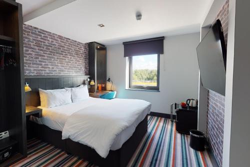 格拉斯哥格拉斯哥乡村酒店的一间卧室设有一张大床和砖墙