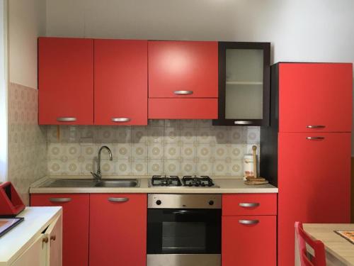 莱乌卡Casa Ada的红色的厨房配有红色橱柜和炉灶
