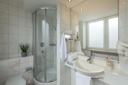汉堡Select Hotel Tiefenthal的白色的浴室设有水槽和淋浴。