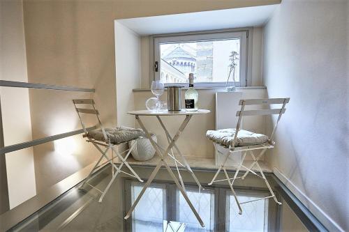 贝加莫ASTRA-Modern Loft Cathedral View的窗户客房内的两把椅子和一张桌子