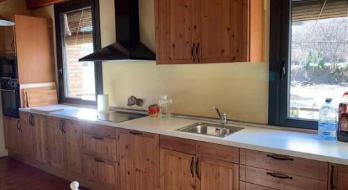 AvellanesEl Molí de Cal Pastisser的厨房配有木制橱柜、水槽和窗户。