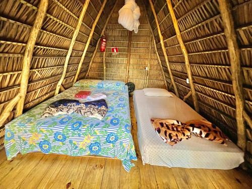 蒂安瓜Z'Alpes Camping e Restaurante的稻草小屋内带两张床的房间