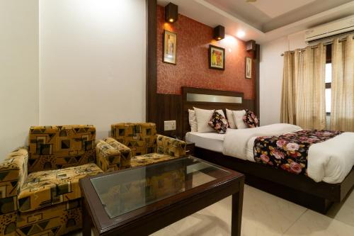 新德里Hotel Baba Deluxe -By RCG Hotels的酒店客房,设有两张床和一张玻璃桌