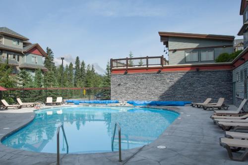 坎莫尔坎莫尔酒店的一个带椅子的游泳池以及一座房子