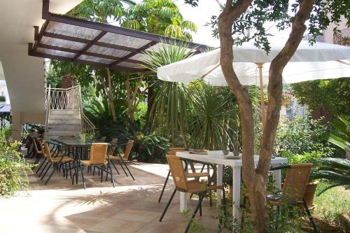 阿莱齐奥Mandarinoarancio的一个带桌椅和遮阳伞的庭院