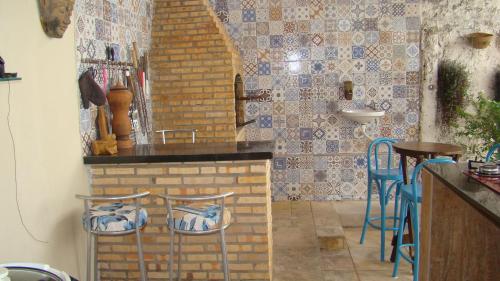 圣路易斯Casa perto da praia com piscina, churrasqueira em SLZ的厨房设有酒吧,里面摆放着蓝色凳子
