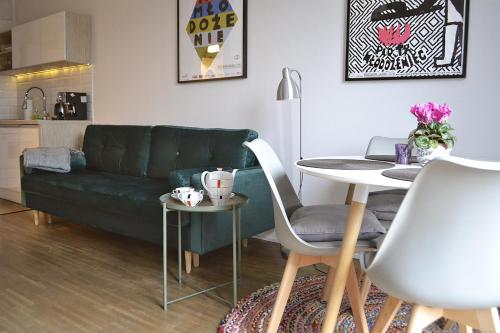 索波特Sopotinn Apartment的客厅配有绿色沙发和桌子