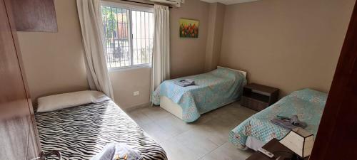 伊瓜苏港Casa Centrica con Yacuzzi !!!的小房间设有两张床和窗户