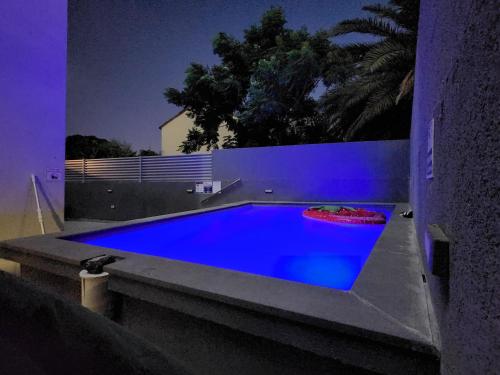 贝特谢安בית דירות - בית אורן的一座拥有蓝色灯光的游泳池