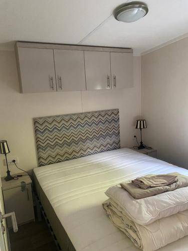 埃尔默洛Mooi verblijf op rustig park的卧室配有白色大床和白色橱柜