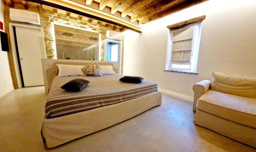 曼托瓦阿科尼科尔特农庄酒店的一间卧室配有一张大床和一张沙发