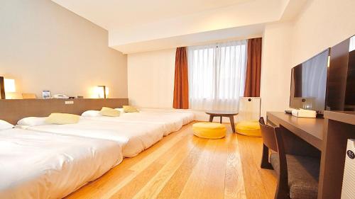 东京东京湾有明华盛顿酒店的酒店客房设有两张床、一张桌子和一台电视。