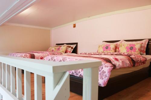 西归浦市西归浦梦幻森林度假屋酒店的一间卧室配有两张带粉色和黄色枕头的床